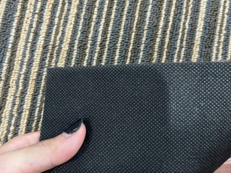 Thảm tấm đế bitumen l&agrave; g&igrave;? Đ&acirc;y l&agrave; d&ograve;ng thảm tấm c&oacute; lớp đế được l&agrave;m từ vật liệu bitumen kết hợp với phụ gia gia cường, gi&uacute;p tấm thảm nặng hơn, chắc hơn v&agrave; ổn định hơn